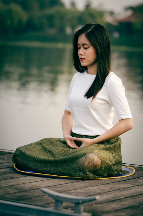 Woman Meditating On Lake