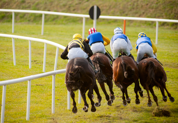 Horses racing on a track with jockeys