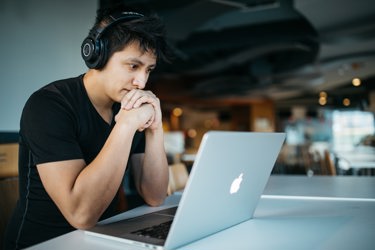 Boy with headphones on looking at laptop