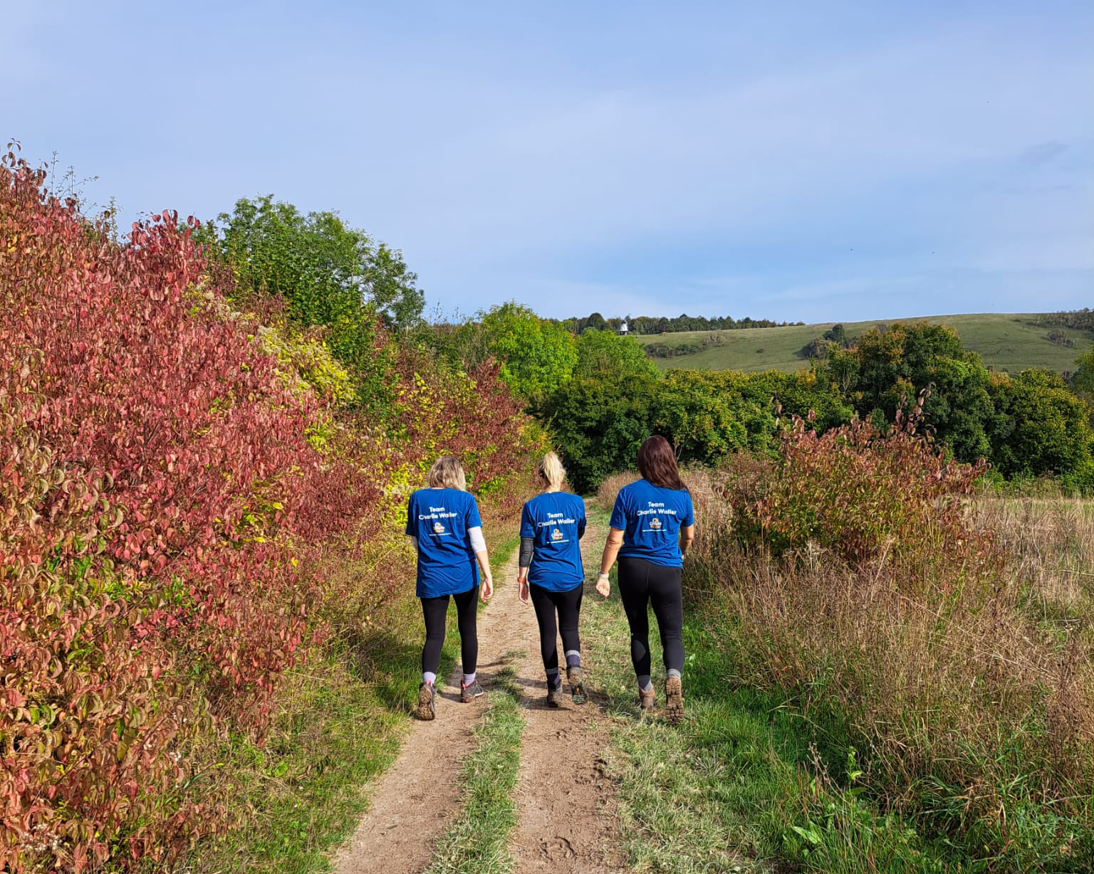 Three women walking in CWT tshirts in the countryside