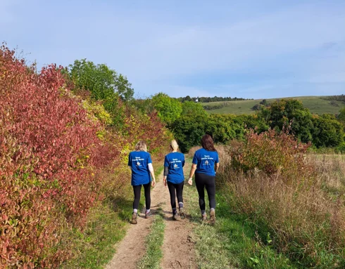 Three women walking in CWT tshirts in the countryside