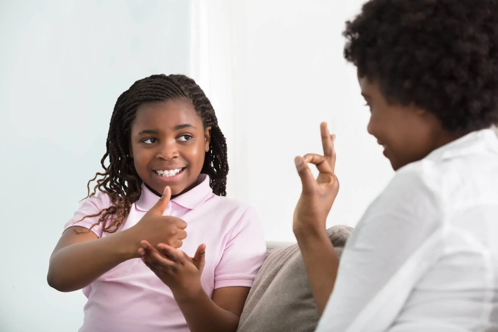 Mother and daughter speaking in sign to each other Mother and daughter speaking in sign to each other