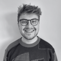 A black and white image of Jack Baldwin, a male with short brown hair smiling at the camera