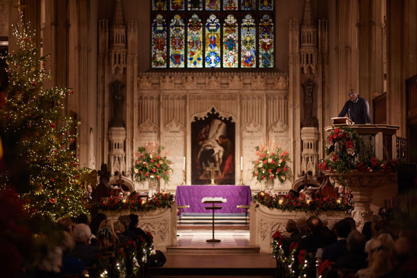 Sol Campbell reading in pulpit of church with view of congregation seated