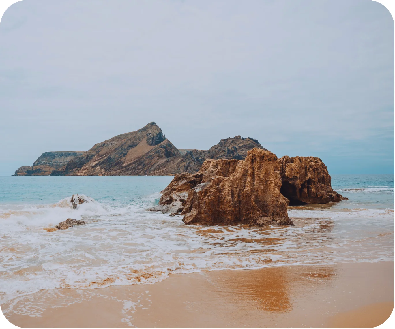 rocks on a beach with a blue sea