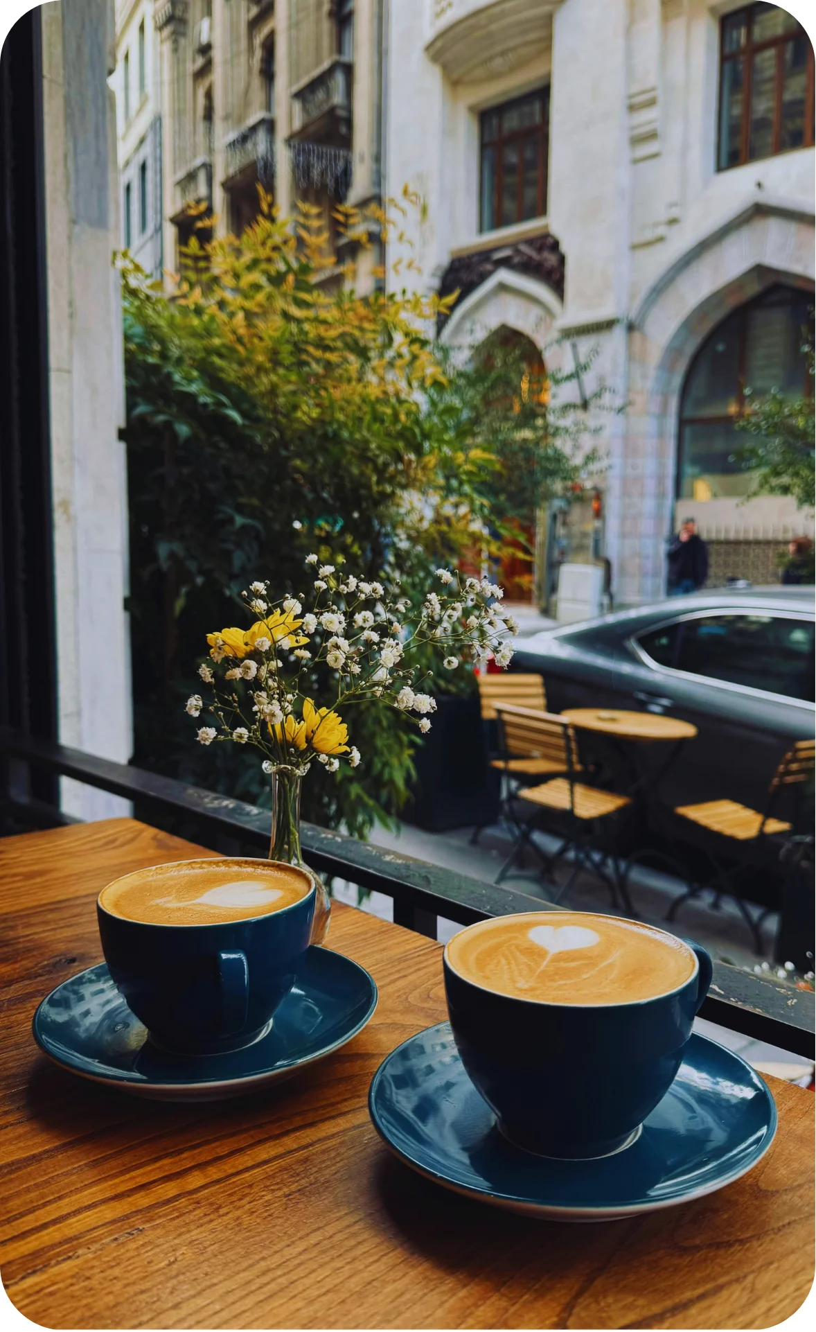 two cups of coffee in the window of a cafe