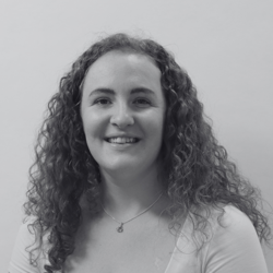 Chelsey, a woman with long curly hair smiling at the camera