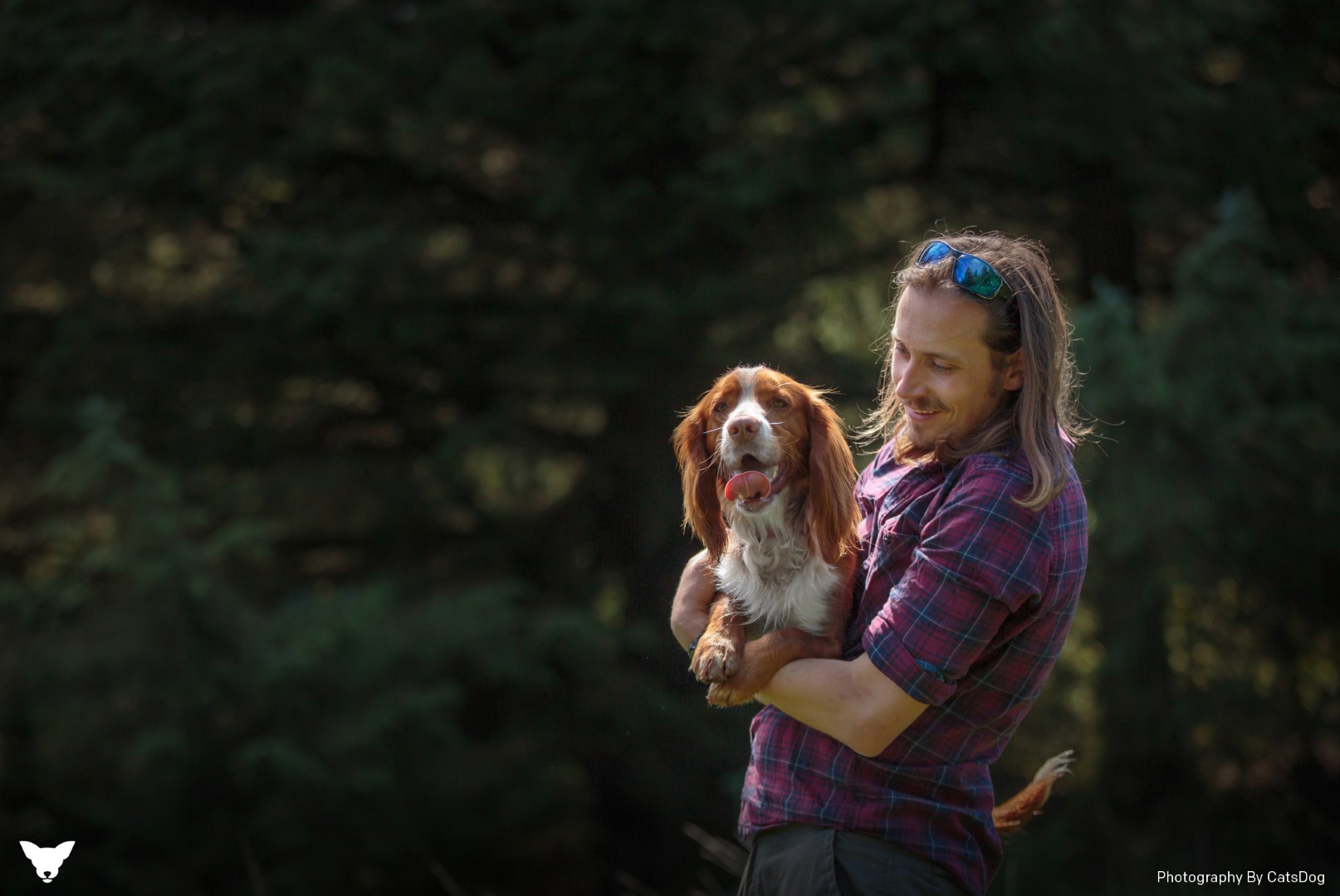 A man with long hair holding a dog