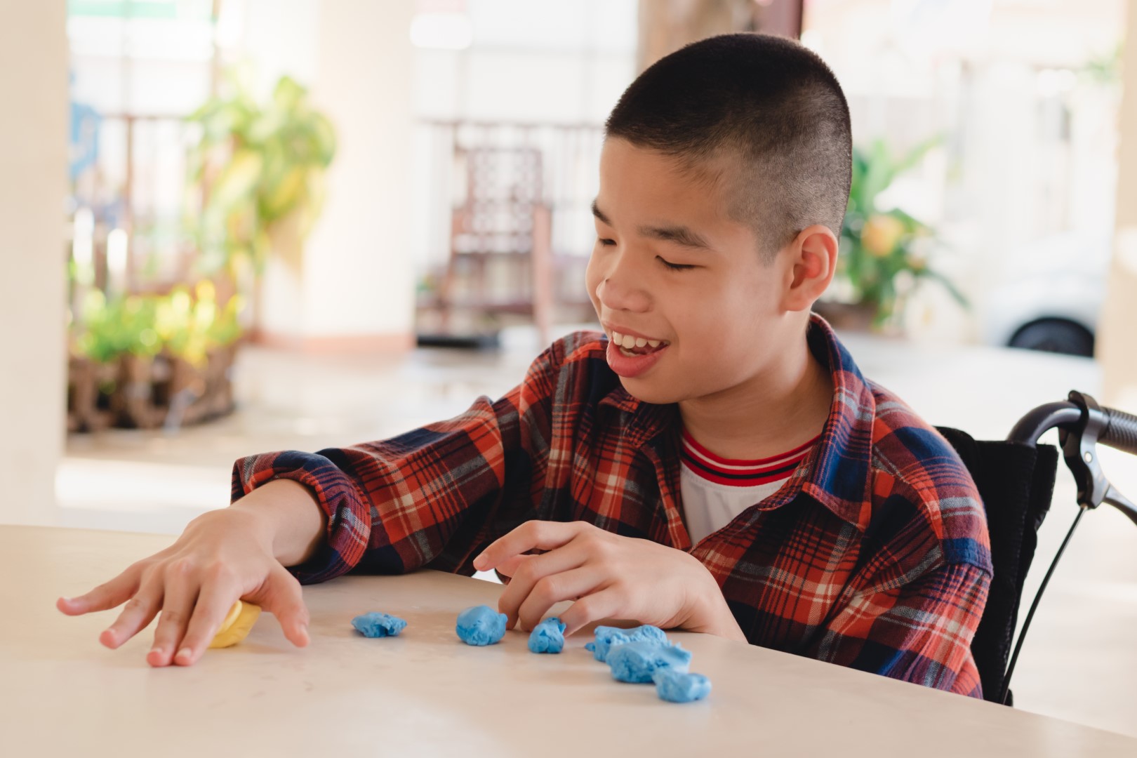 boy in wheelchair at table with a game