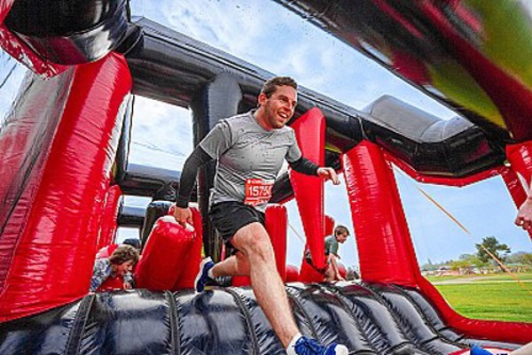 A man running across the inflatable course