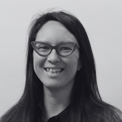 Martha, a woman with long hair and glasses smiling at the camera