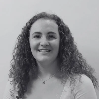 Chelsey, a woman with long curly hair smiling at the camera Chelsey, a woman with long curly hair smiling at the camera