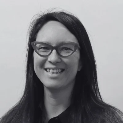 Martha, a woman with long hair and glasses smiling at the camera Martha, a woman with long hair and glasses smiling at the camera