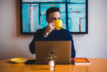 Guy at laptop drinking coffee