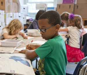 A young black boy drawing