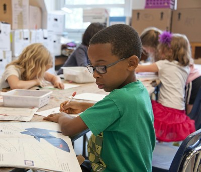 A young black boy drawing