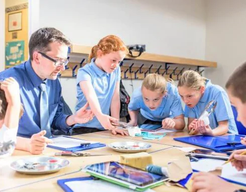 Primary school children with teacher around a table