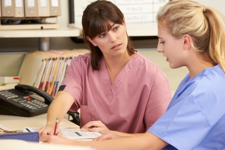 two nurses talking at desk