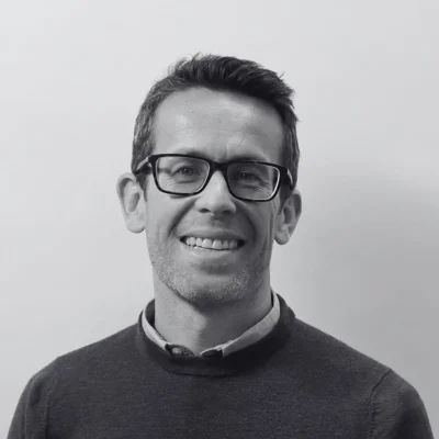 Nick, a man with short hair and glasses smiling at the camera Nick, a man with short hair and glasses smiling at the camera